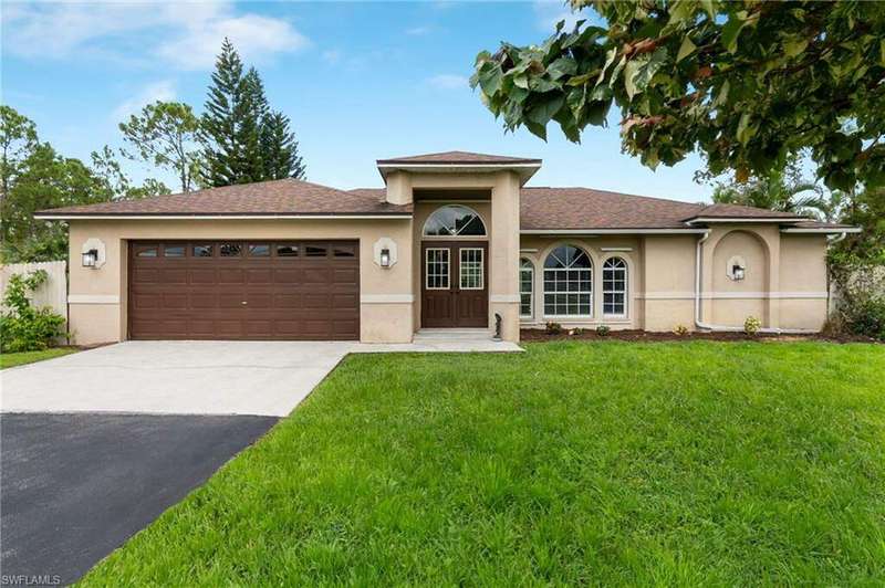 View of front facade with a garage and a front lawn