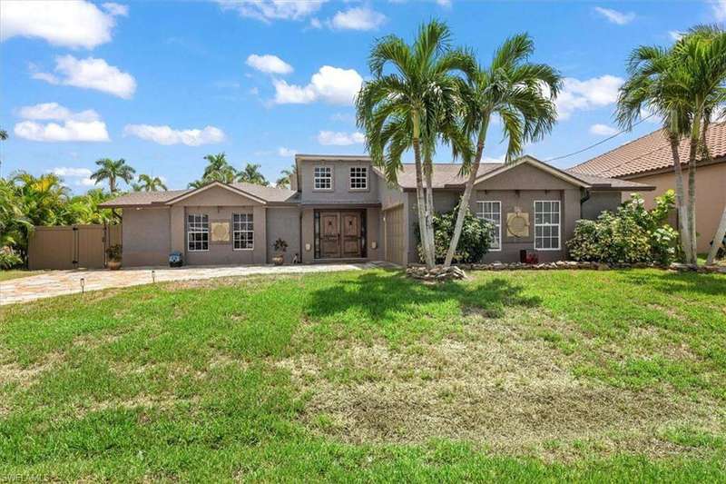 View of front of property featuring stucco siding, a front yard, and an attached garage
