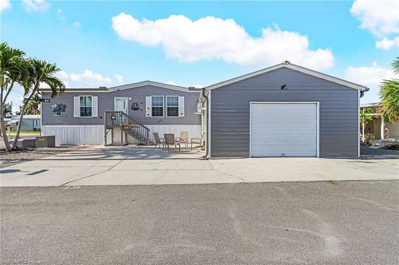 Manufactured / mobile home with a detached garage, an outbuilding, and concrete driveway