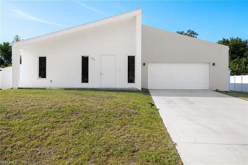 View of front facade featuring a garage, stucco siding, and concrete driveway