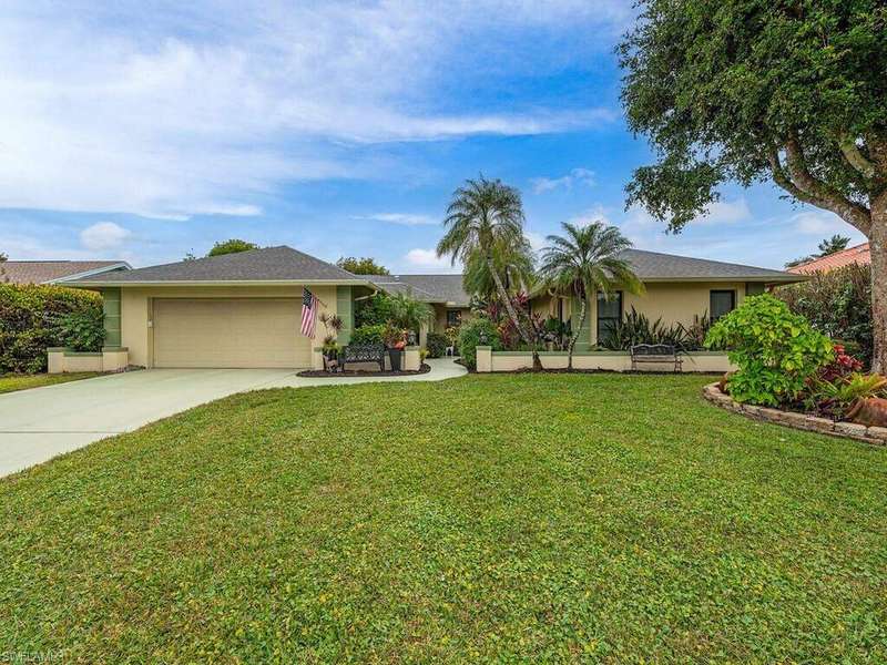 Ranch-style home featuring a garage and a front lawn
