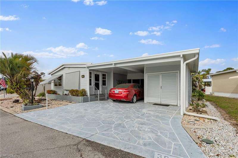 View of front of home featuring an attached carport and driveway