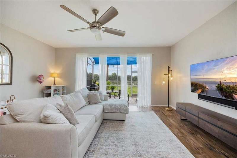 Living room with wood finished floors, a ceiling fan, and baseboards
