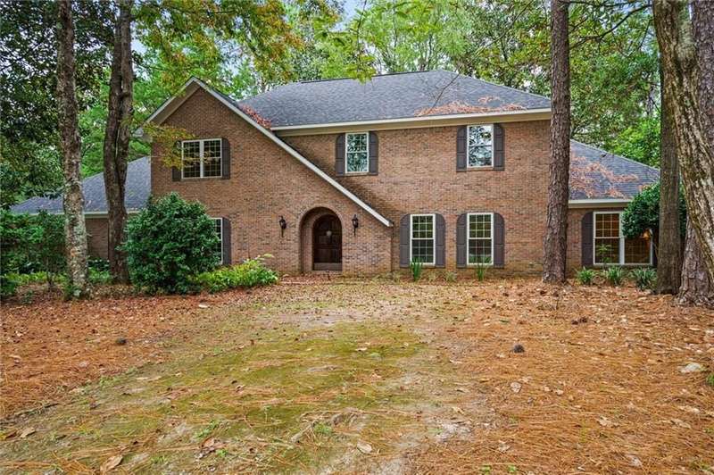 A magnificent round-topped solid custom front door, graced by a dramatic knocker greets family and friends to this meticulously maintained one owner European style custom brick home.