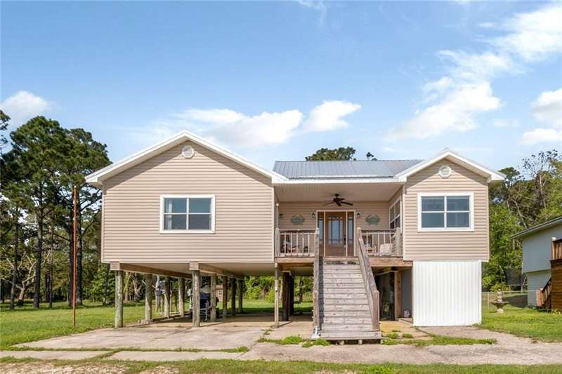 Rear view of house with a carport, stairway, driveway, ceiling fan, and metal roof