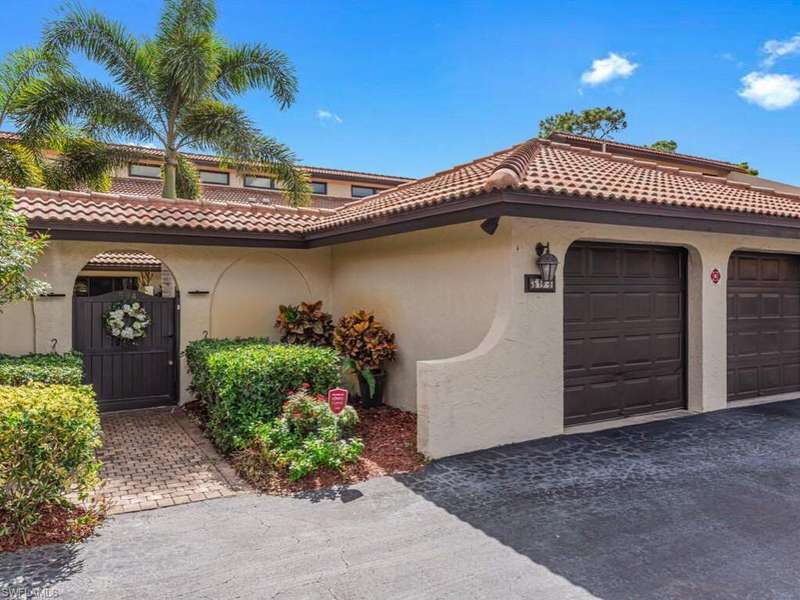 Mediterranean / spanish house with stucco siding, an attached garage, a tiled roof, and driveway