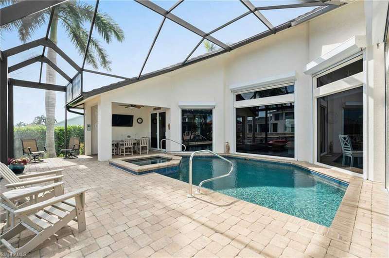 View of swimming pool featuring ceiling fan, an in ground hot tub, a lanai, and a patio area