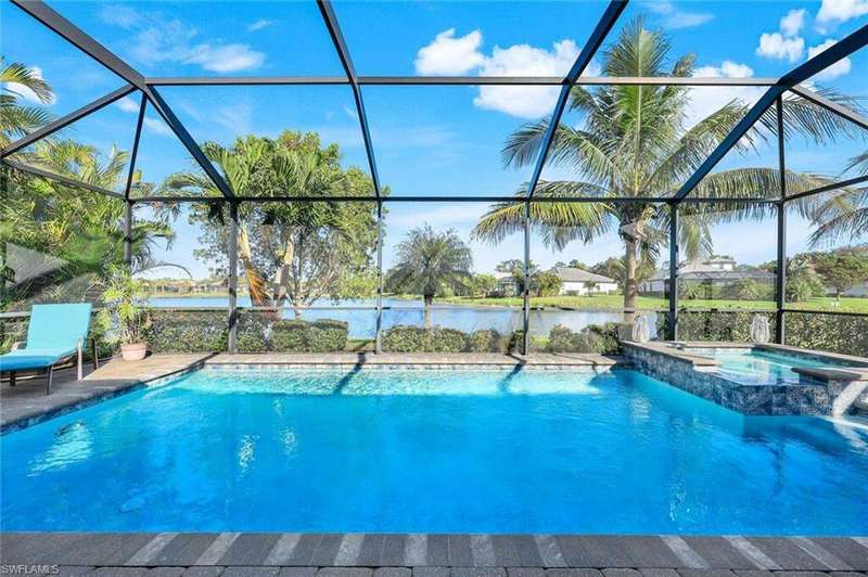 View of swimming pool featuring a lanai, an in ground hot tub, and a water view