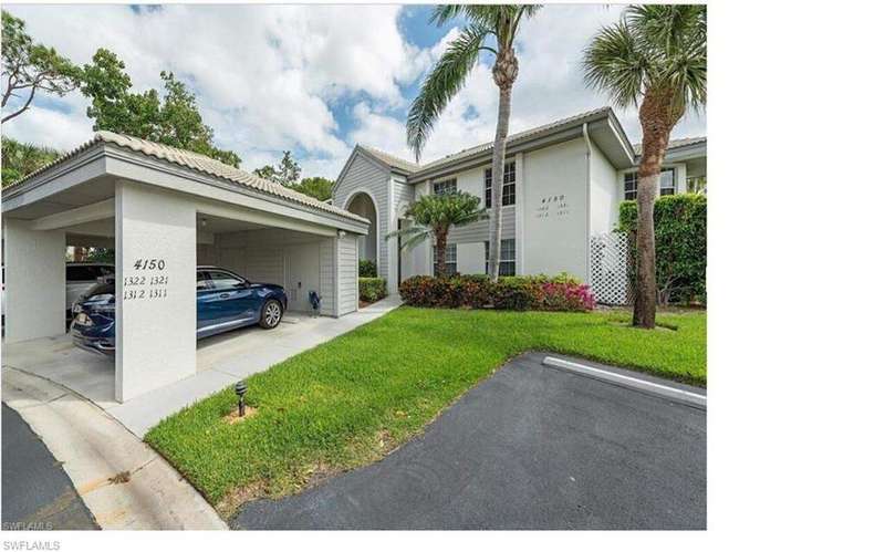 View of front of property featuring a front lawn, covered and uncovered parking, and stucco siding
