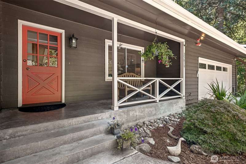 Country-style Pacific Northwest rambler with gorgeous Redwood Siding includes a walkout basement with full apartment on 1.1 Acres -- And who doesn't love a welcoming covered porch?