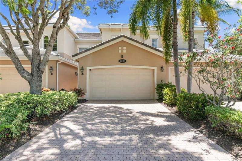 View of property featuring stucco siding, decorative driveway, and an attached garage