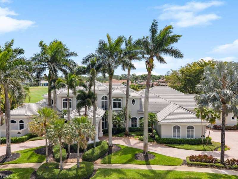 Mediterranean / spanish-style home featuring stucco siding, a tiled roof, curved driveway, and a front yard