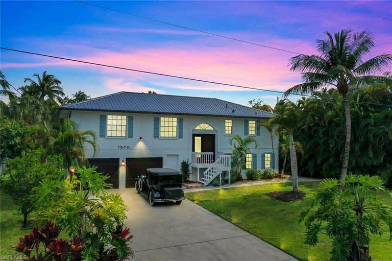 View of front of house featuring a garage and a yard