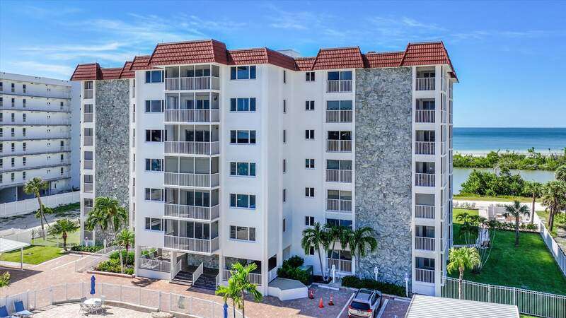 Community pool featuring view of water and beach