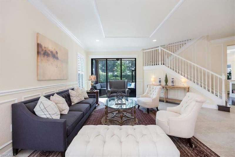 Tiled living room with a raised ceiling and crown molding