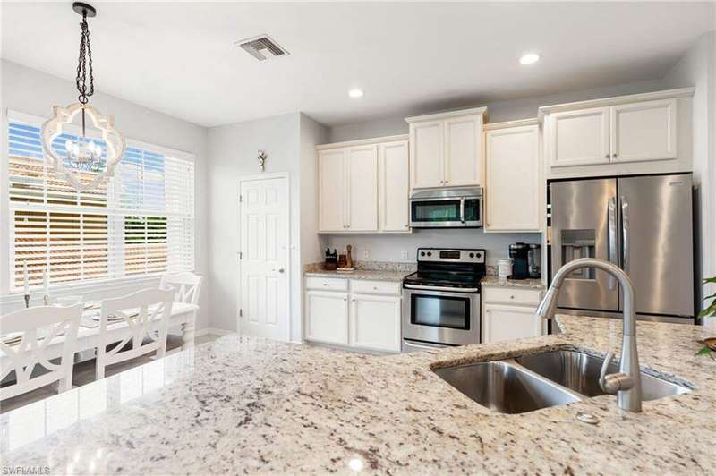 Spacious kitchen with ample storage space, stainless steel appliances, granite countertops, light cabinetry, and walk-in pantry!