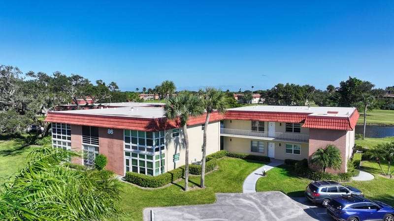 View of building exterior with uncovered parking