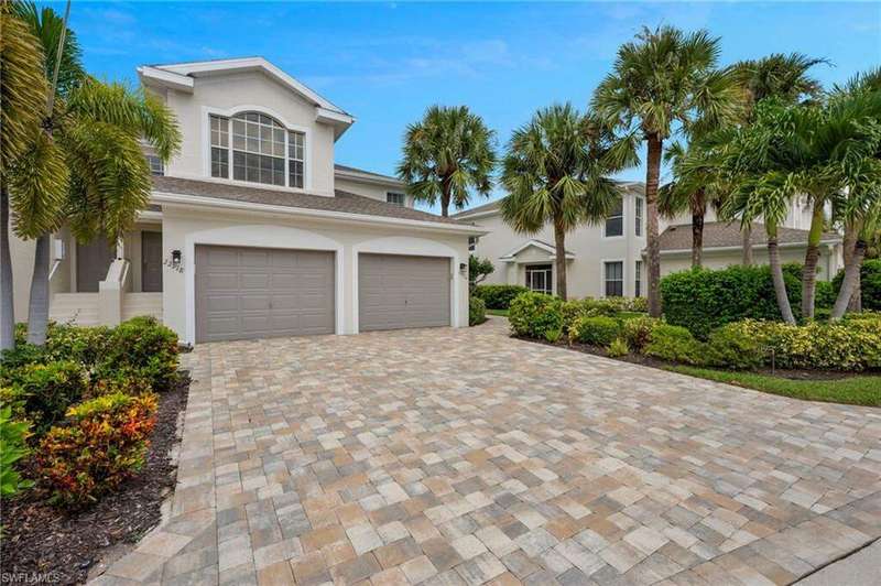 View of front of property featuring a garage, stucco siding, and decorative driveway