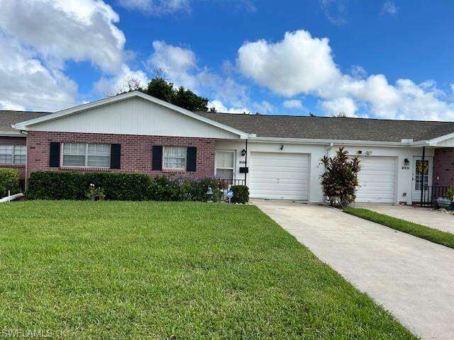 Single story home featuring driveway, a front yard, brick siding, and an attached garage