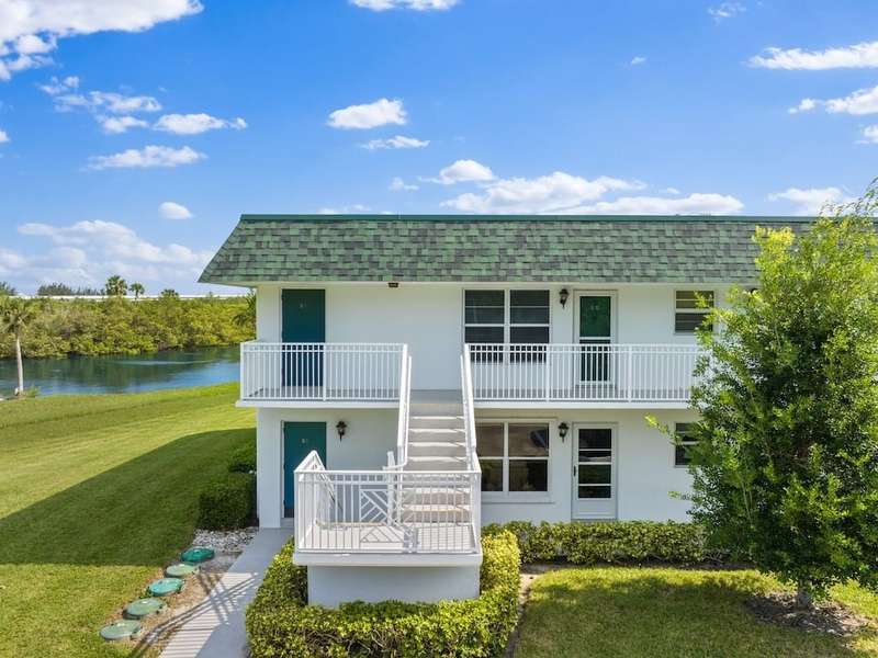 Back of property featuring roof with shingles, man