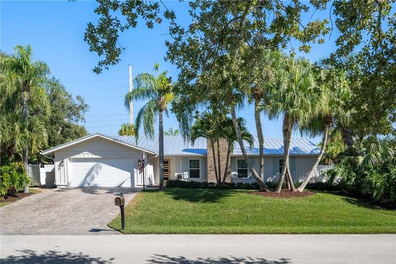 Single story home featuring a front lawn, board an