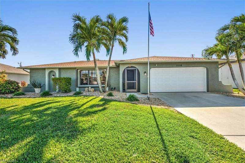 Single story home with a garage and a front yard