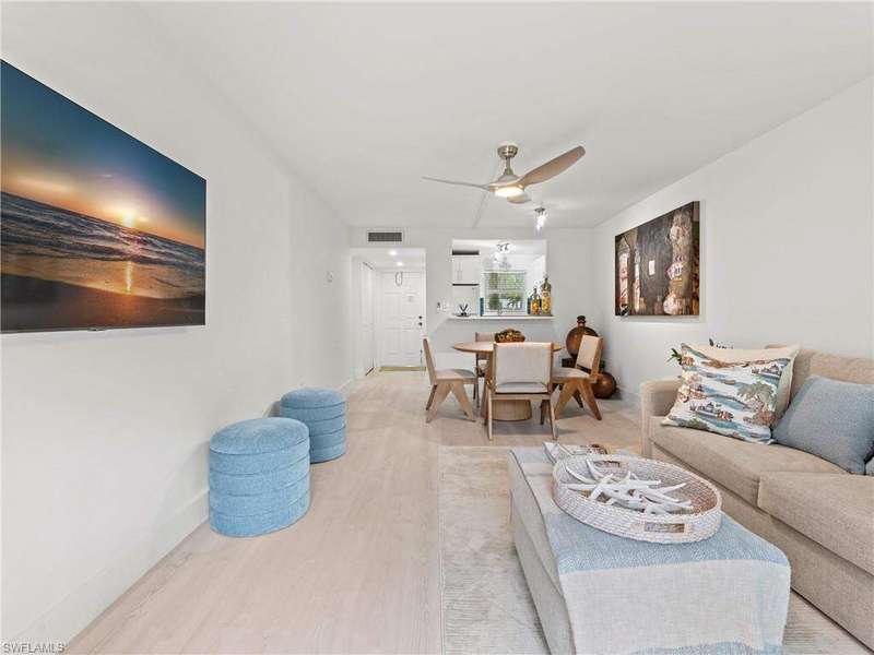 Living area with baseboards, visible vents, light wood-style floors, and ceiling fan