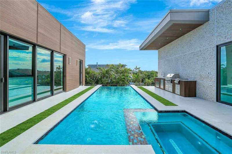 View of swimming pool featuring a patio area, exterior kitchen, an in ground hot tub, and grilling area