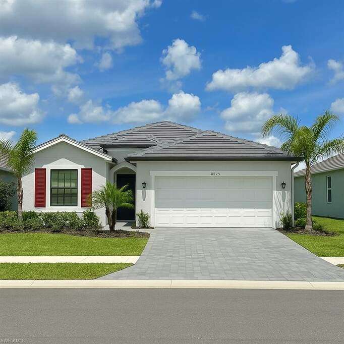Single story home featuring a tile roof, a front lawn, driveway, an attached garage, and stucco siding