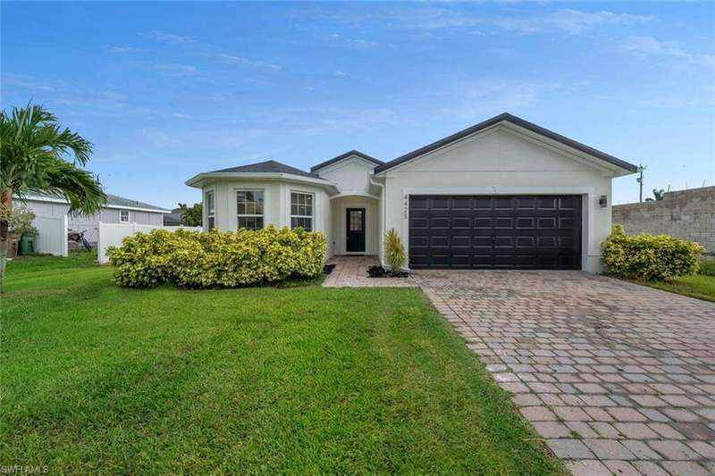 Ranch-style house featuring a garage and a front yard