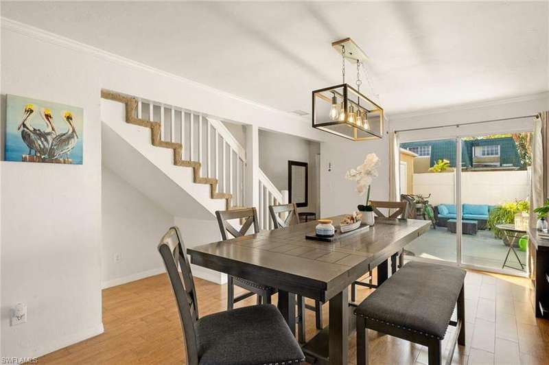 Dining room with crown molding, wood finished floors, stairs, and a chandelier