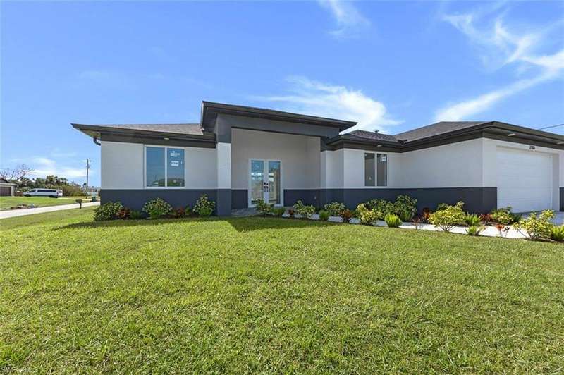 Prairie-style home with a garage, stucco siding, french doors, and a front yard
