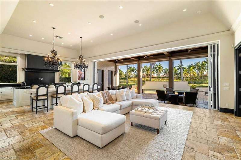 Living area featuring stone tile flooring, recessed lighting, and a chandelier