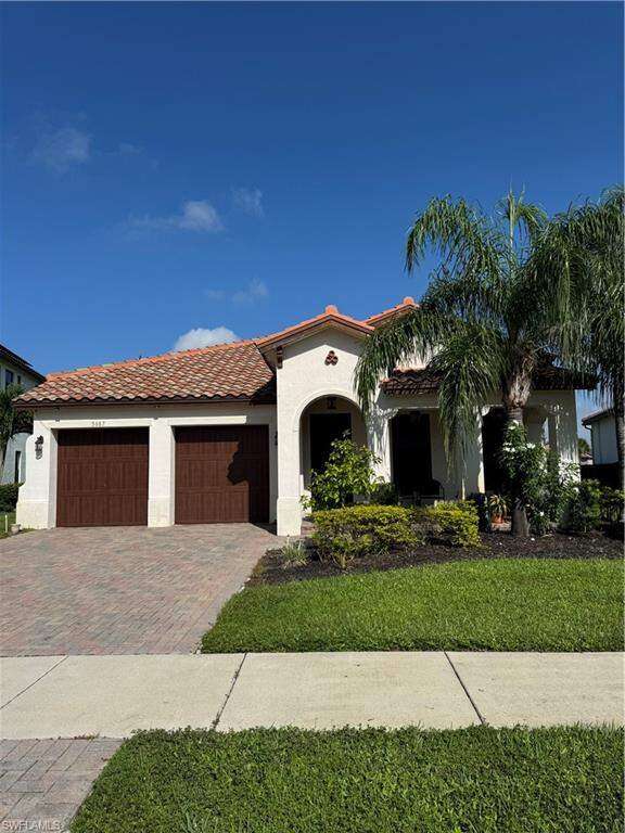 Mediterranean / spanish-style home with paved driveway, 2 car attached garage and a front porch.