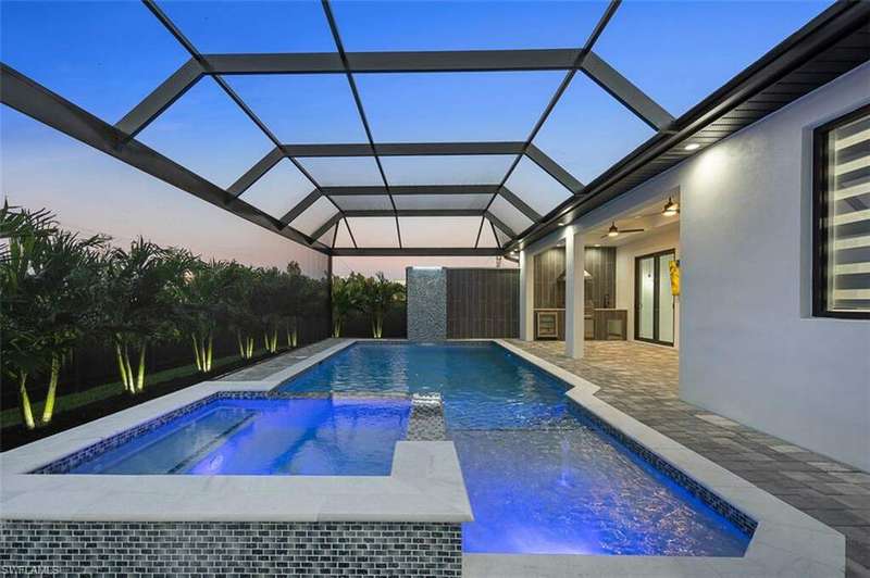 View of swimming pool featuring a patio area, a lanai, and an in ground hot tub