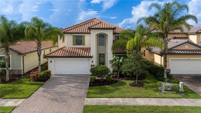 Mediterranean / spanish home with stucco siding, decorative driveway, a tile roof, a garage, and a front lawn