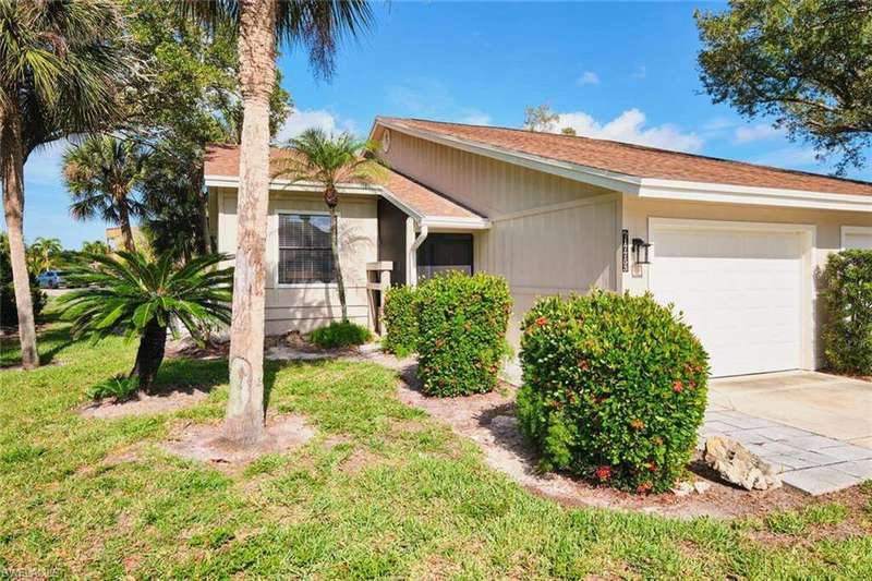 Single story home featuring a garage, driveway, a front lawn, and a shingled roof
