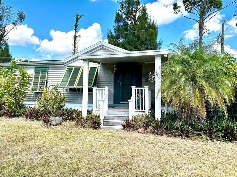 View of front of property with covered porch and a front lawn