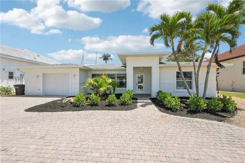View of front facade featuring decorative driveway, a garage, and stucco siding