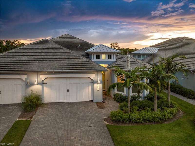 View of front of house with stucco siding, decorative driveway, and a garage