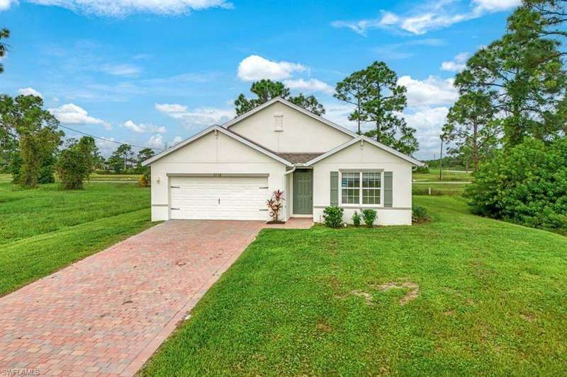 Single story home featuring a garage and a front lawn