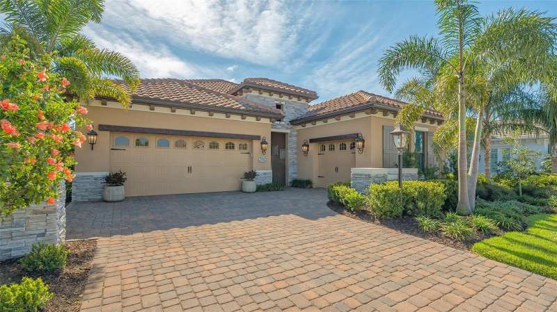 Stone paver driveway and walkway lead you to a covered front entry