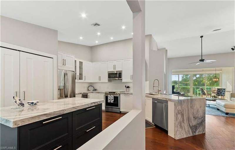 Kitchen featuring visible vents, appliances with stainless steel finishes, dark wood-type flooring, dark cabinets, and a center island