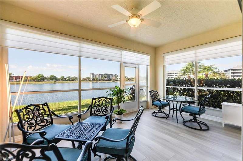 Sunroom featuring a ceiling fan and a water view