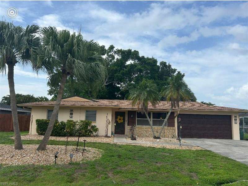 Single story home with stucco siding, a garage, and driveway