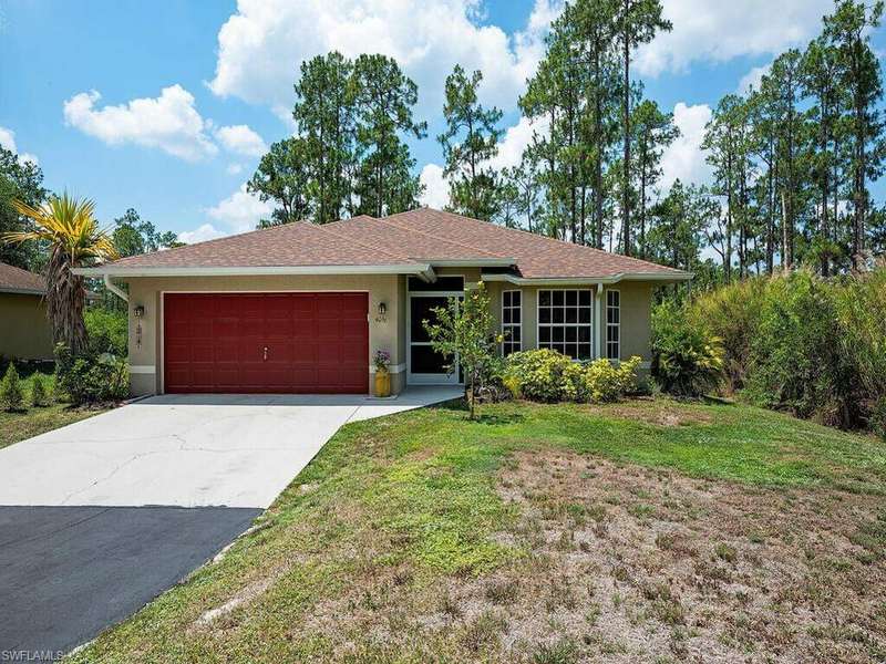 Single story home featuring a front yard and a garage