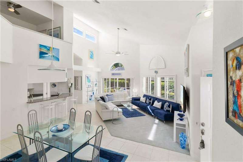 Tiled living room featuring a high ceiling