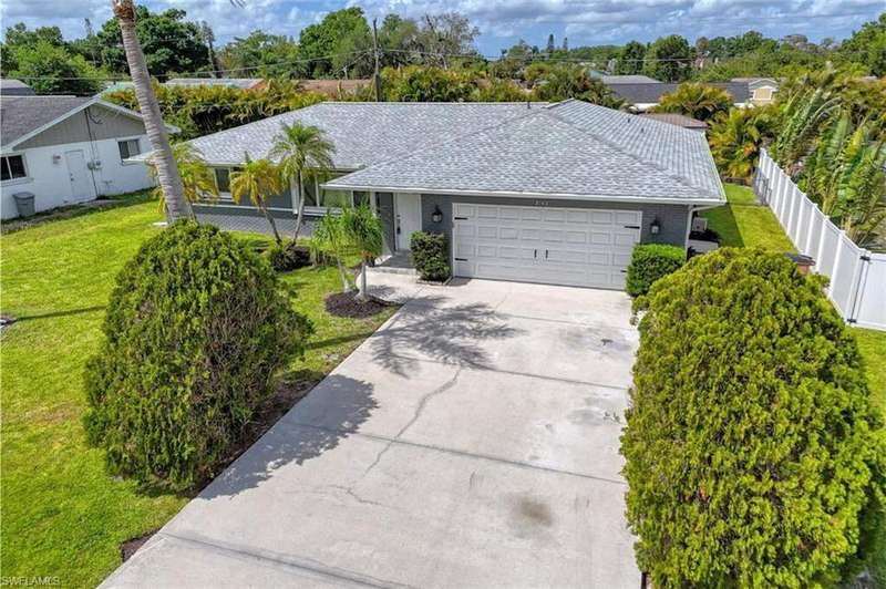 Ranch-style home featuring a garage, fence, a front lawn, and concrete driveway
