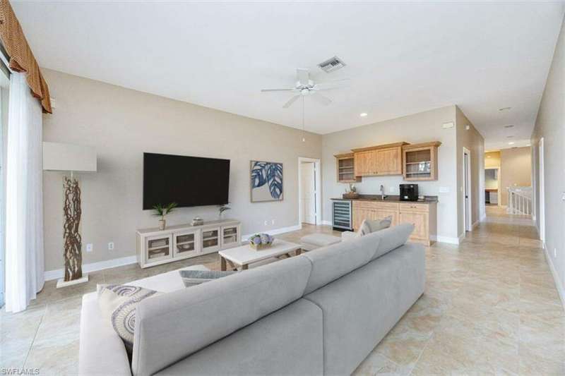 Living room with ceiling fan, sink, and wine cooler