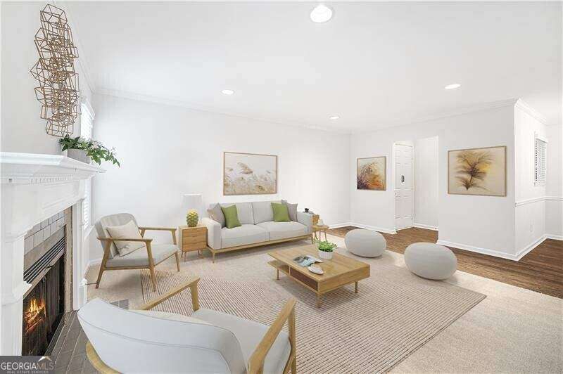 Living room featuring a fireplace, ornamental molding, recessed lighting, and engineered wood floors